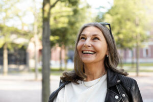 Mulher madura sorridente de cabelos grisalhos mostrando dentes alinhados com aparelho ortodôntico na Clínica Lima Odontologia em Bauru.